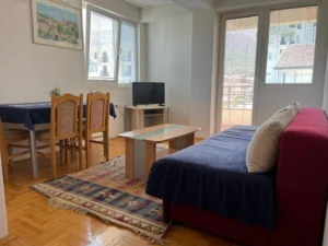 a couch, dining area, tv, and windows